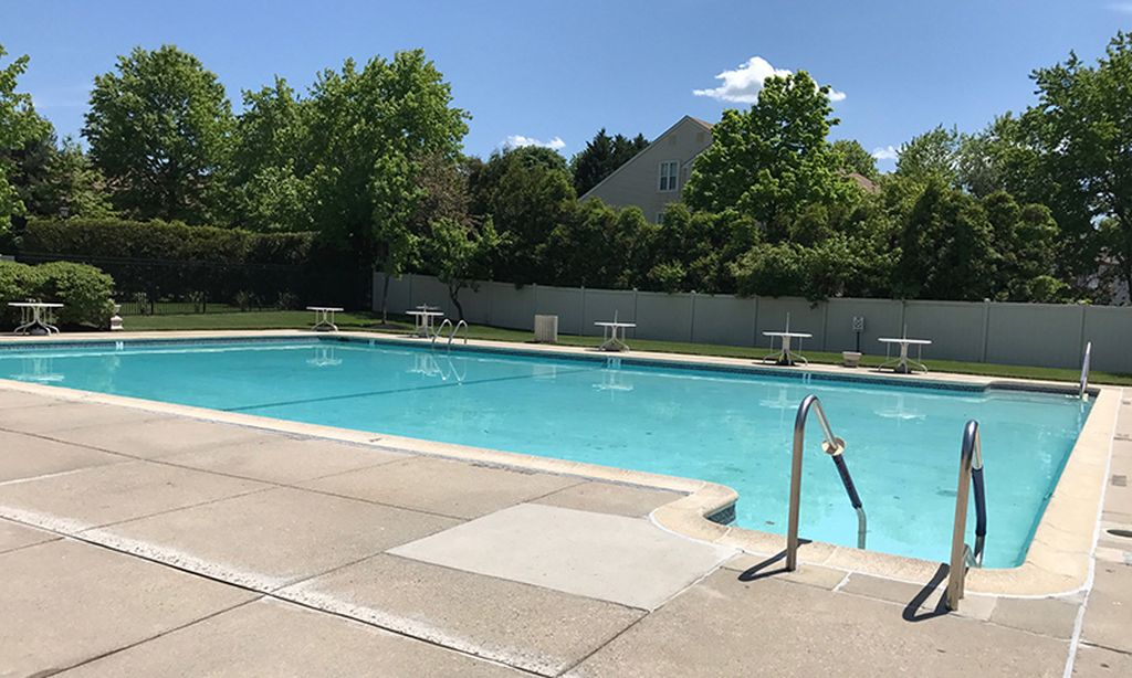 Residential community outdoor pool surrounded by trees